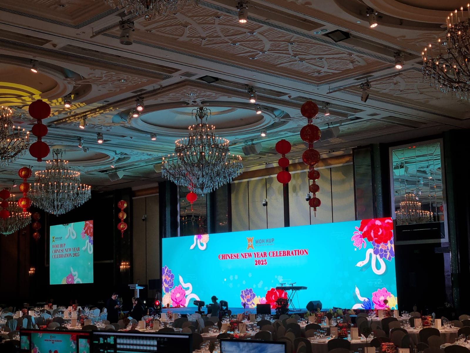 Woh Hup Chinese New Year dinner stage with LED backdrop and warm ambient ballroom lighting